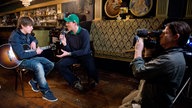 Manuel Unger im Interview mit Jake Bugg, der seine Gitarre hält.