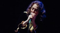 Regina Spector singt mit geschlossenen Augen und hält das Mikro mit beiden Händen fest
