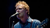 Glen Hansard, Sänger mit roten Locken und Bart, singt ins Mikro und spielt Akustikgitarre.