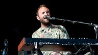 Keyboarder im bunten Hemd singt mit geschlossenen Augen