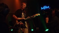 Sänger der Band "Guru Guru" mit Gitarre.