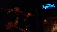 Dunkle Bühne mit leuchtendem Rockpalast-Schriftzug auf der rechten Seite.