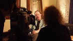 Ein Mitglied von Birth-Control wird interviewt und gefilmt.