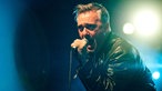 Der Sänger der Band "The Undertones" singt in ein Mikrofon