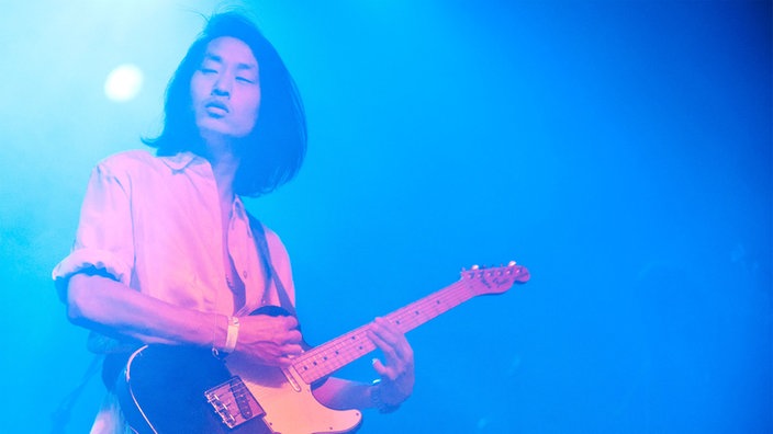 Ein Gitarrist der Band "The Asteroids Galaxy Tour" spielt Gitarre