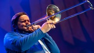 Kelsey howard an der Posaune spielt aus vollen lungen