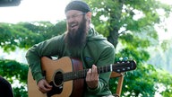 Groundation unplugged, Sänger mit Akustikgitarre