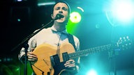 Hugo White singt und spielt gitarre