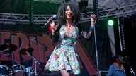 Die Sängerin Hollie Cook im Flamingobedruckten Kleid