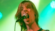 Sänger von John Coffey singt enthusiastisch ins Mikrofon, er sieht ein bisschen aus wie Mike Stern