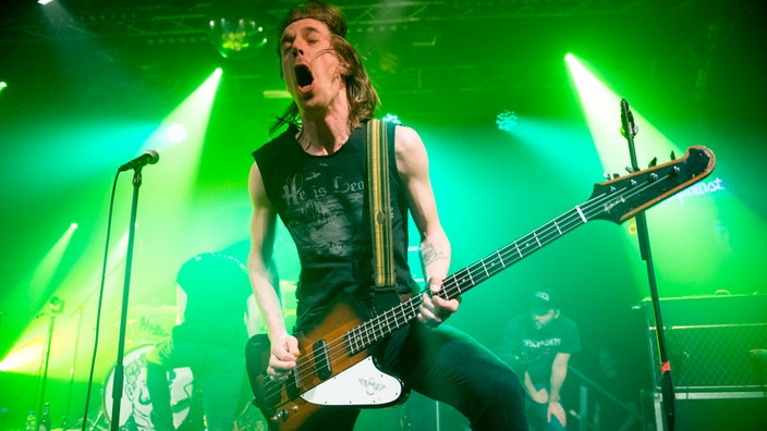 Bassist von John Coffey geht richtig ab, Mund weit geöffnet, Bass hängt tief, vermutlich spielt er gerade einen richtig fetten Basston
