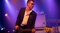 Bassist von King King, spielt einen lässigen Basslauf auf seinem MusicMan Stingray Bass
