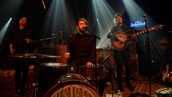Mister and Mississippi Band steht um das Schlagzeug rum wo der Frontmann trommelt und singt