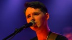 Sänger von New Desert Blues singt und schaut süß am Mikrofon vorbei
