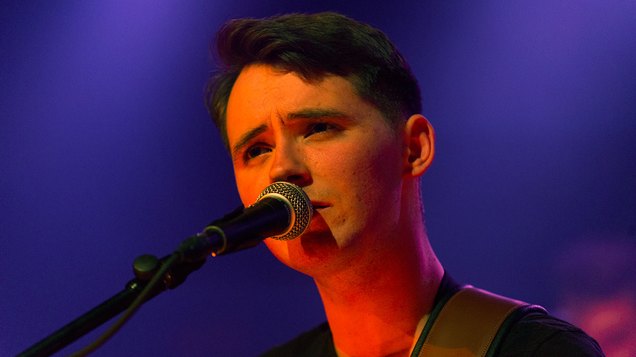 Sänger von New Desert Blues singt und schaut süß am Mikrofon vorbei