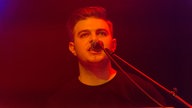 Frontmann von New Desert Blues singt geradeweg ins Mikrofon hinein, Frisur lässig nach hinten