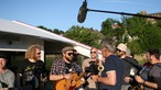 Golden Kanine spielen einen Unplugged Song auf einem Boot