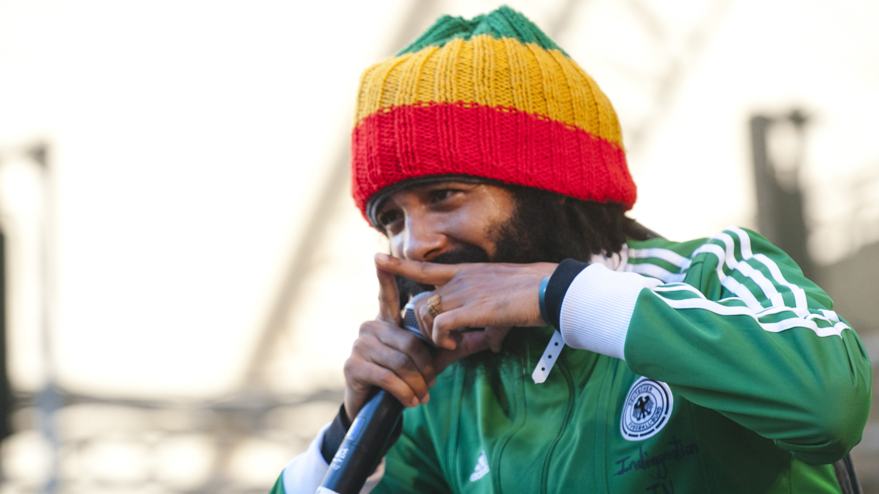 Protoje macht ein zeigefinger Zeichen beim singen