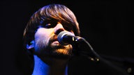 Bandmitglied von Moss singt ins Mikrofon 