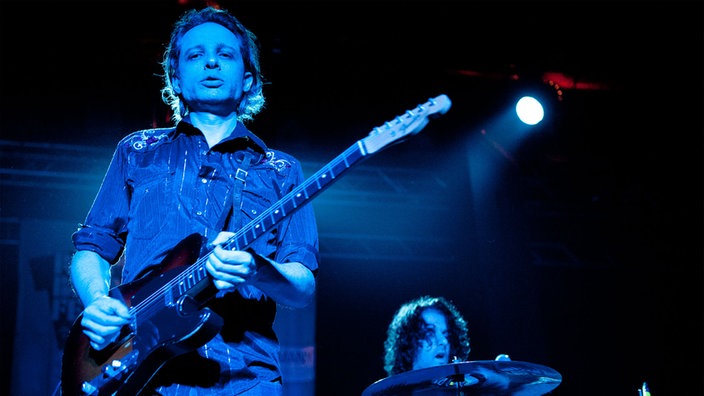 Der Gitarrist von "The Jon Spencer Blues Explosion" steht auf der Bühne undspielt