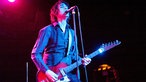 Sänger von "The Jon Spencer Blues Explosion" steht auf der Bühne und singt