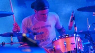 Schlagzeuger der Beatsteaks in Nahaufnahme vor einer Wand aus blauen Leuchtdioden.