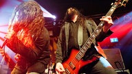 Sänger und Bassist der Spiritual Beggars mit langen Locken im bunten Bühnenlicht.