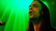 Zodiac-Sänger im grünen Licht schaut angestrengt nach unten