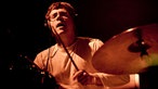 Der Drummer der Band spielt mit verschlossenen Augen.