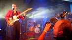 Im rechten Vordergrund steht ein Kameramann, der Anna Calvi fotografiert während auf der linken Seite eben diese performt.