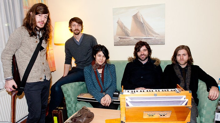 Die fünf Mitglieder der band Other Lives sitzen Backstage zusamen auf und um eine Couch.