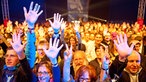 Die Menschen in der ersten Reihe des Publikums recken ihre Hände nach oben.