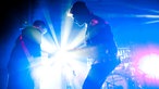 Die Silhouetten zweiter Gitarristen im gleißenden blauen Licht