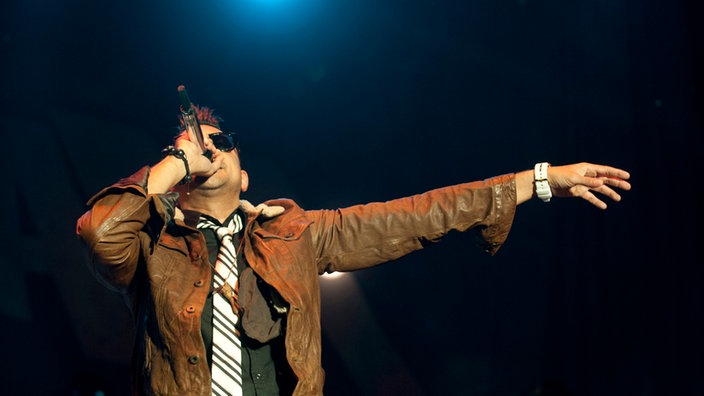 Sean Paul streckt beim singen den Arm aus