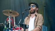 Drummer mit Sonnenbrille und Kappe