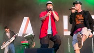 Zwei der drei sänger und der Keyboarder an der keytar im hintergrund