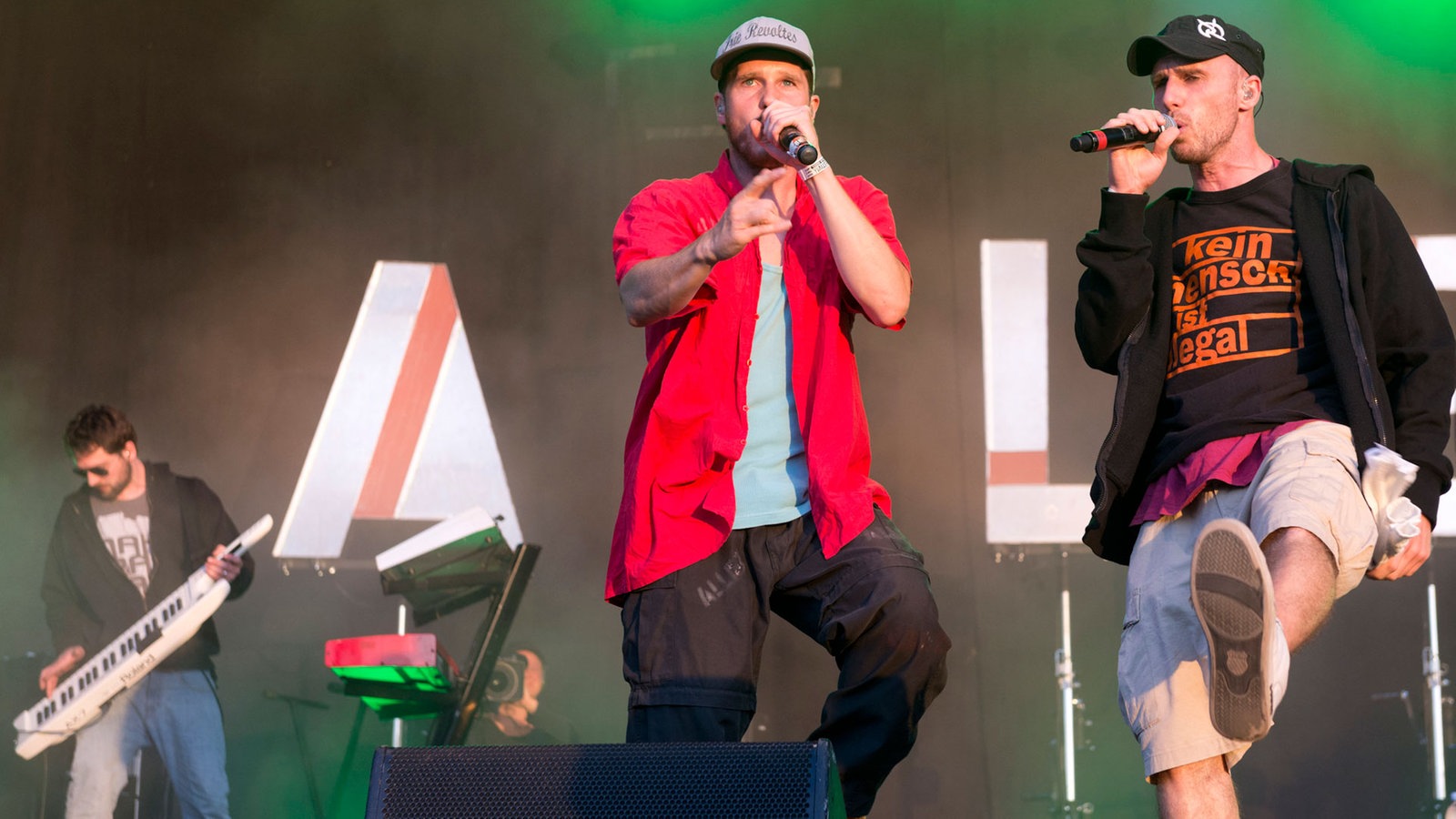 Zwei der drei sänger und der Keyboarder an der keytar im hintergrund