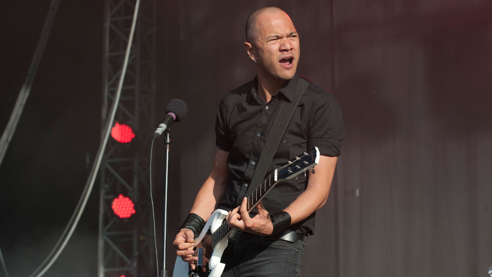Danko Jones schaut zu seinen Bandkollegen rüber während er auf seiner weißen Gitarre spielt
