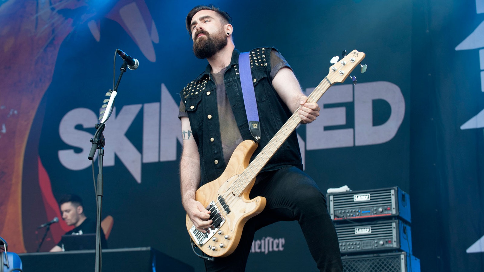 Der Bassspieler von Skindred spielt mit geschlossenen Augen