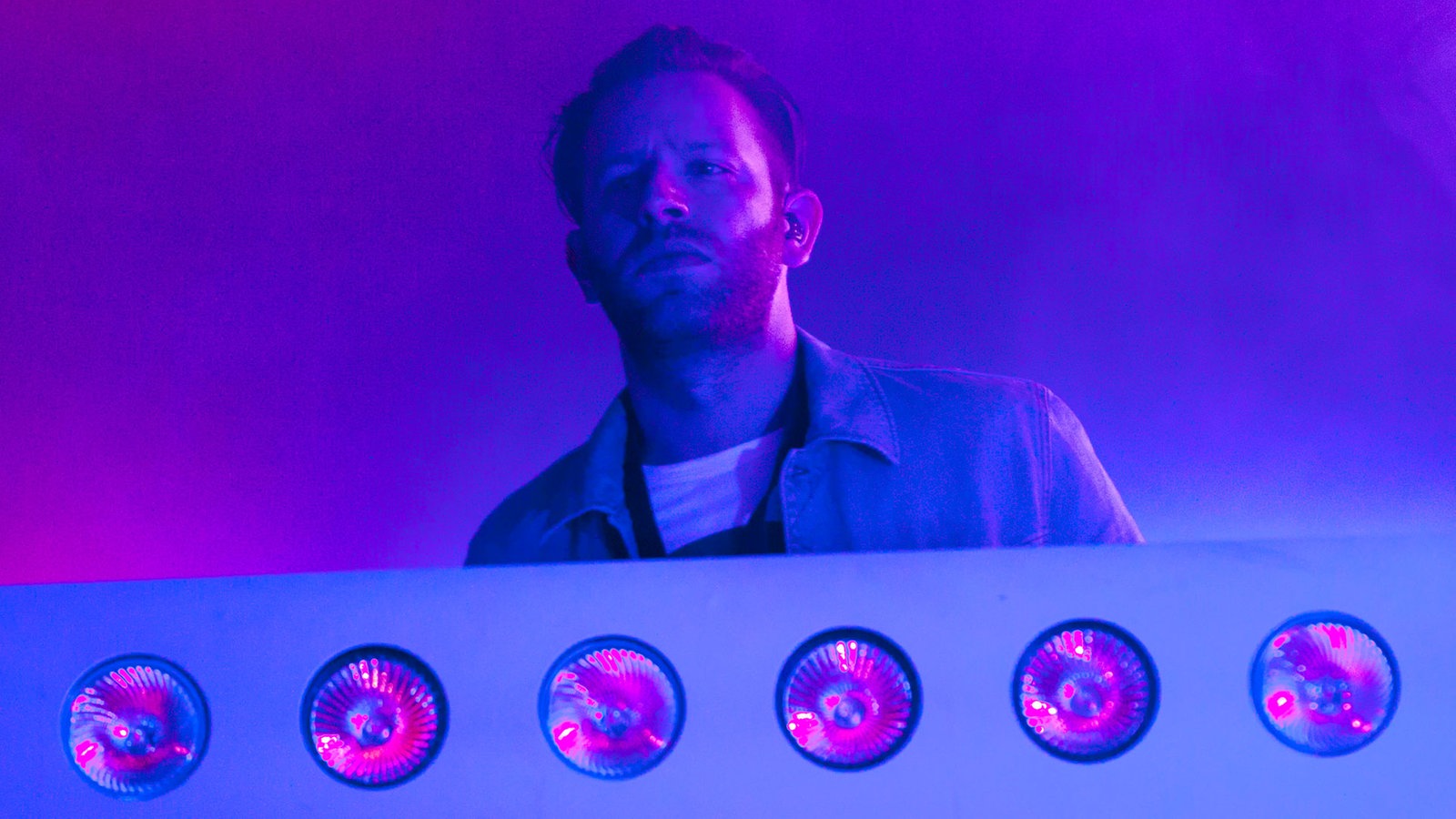 Die Bühne ist insgesamt nun in blau-lila licht getaucht. der Keyboarder schaut versonnen nach vorn