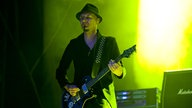 Der Gitarrist spielt, das Licht ist grün-gelb