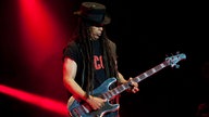 Cass, der Bassist von Skunk anansie schaut auf sein Instrument