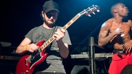 Der Gitarrist von Skip The Use beim Solo - im Hintergrund der Energie geladene Sänger.