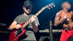 Der Gitarrist von Skip The Use beim Solo - im Hintergrund der Energie geladene Sänger.