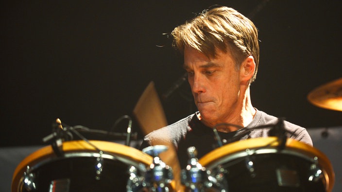 Der Drummer der Band sieht angestrengt nach unten.