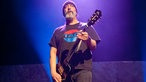 Der zweite Gitarrist der Band sieht ins Publikum.