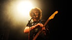 State Radio's Sänger verändert etwas an seiner Gitarre