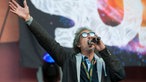 Andrew der ansager der Red stage hat einen arm nach oben gestreckt und ruft ins mikrophon