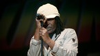 Ein Sänger mit Dread-Locks hält sich am Mikrofon-Ständer fest