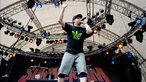 Ein Rapper mit kurzen Hosen steht auf der Bühne und hebt die Hand
